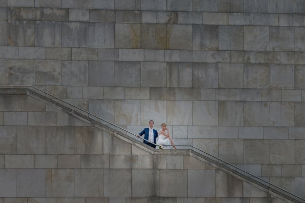 Brautpaar steht auf einer Treppe vor einer Buntsandsteinwand am Kleinen Haus in Braunschweig